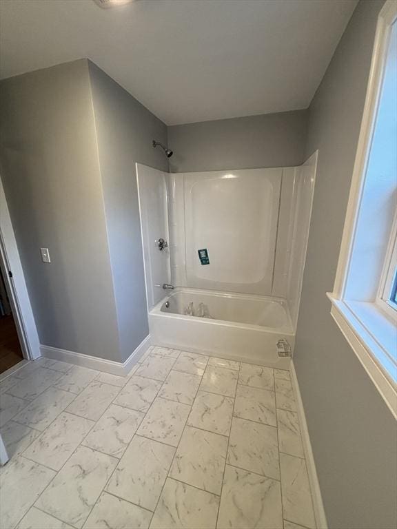 bathroom featuring baseboards, shower / tub combination, and marble finish floor