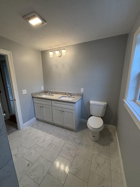 bathroom featuring a sink, baseboards, double vanity, and marble finish floor