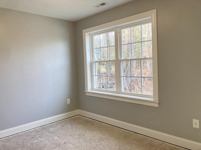 unfurnished room with baseboards and visible vents