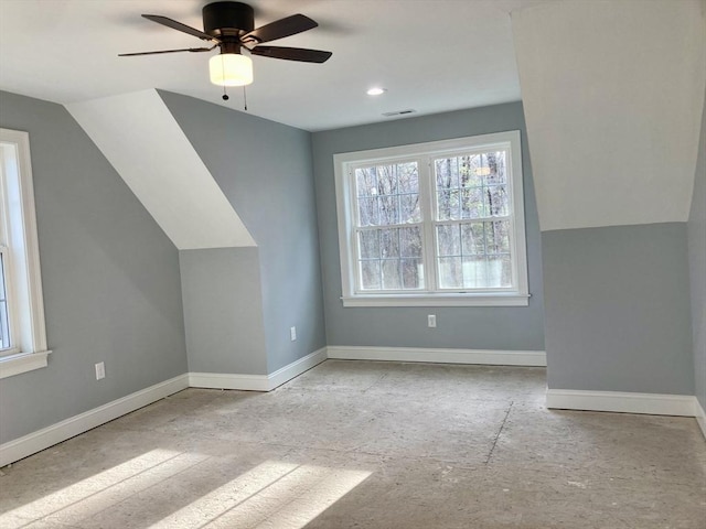 additional living space featuring baseboards, ceiling fan, a healthy amount of sunlight, and visible vents