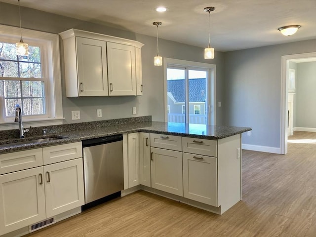 kitchen with visible vents, a peninsula, light wood-style floors, a sink, and dishwasher