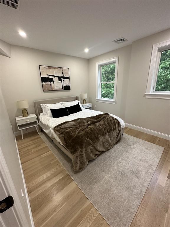 bedroom with light hardwood / wood-style flooring and multiple windows