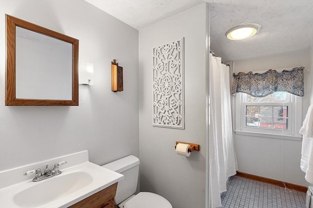 bathroom featuring vanity, tile patterned flooring, toilet, and a textured ceiling