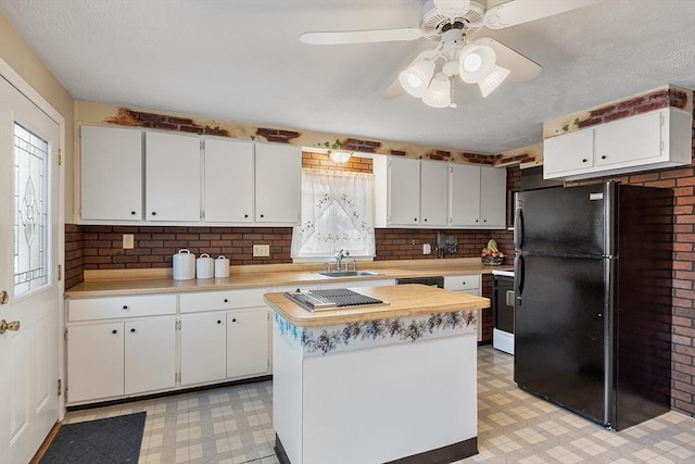 kitchen featuring black refrigerator, white electric stove, a center island, and white cabinets