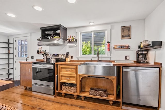 kitchen featuring butcher block countertops, hardwood / wood-style floors, sink, and appliances with stainless steel finishes