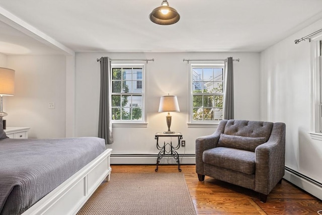 bedroom featuring wood-type flooring and a baseboard heating unit