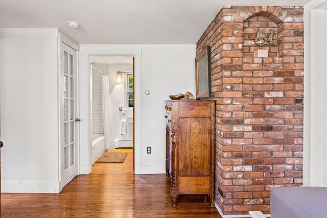 hall with a baseboard heating unit and wood-type flooring