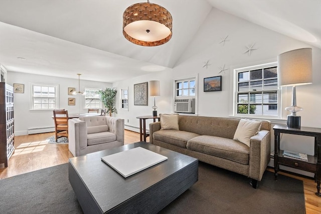 living room featuring cooling unit, light hardwood / wood-style flooring, high vaulted ceiling, and baseboard heating