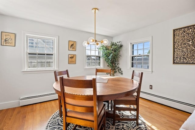 dining area featuring an inviting chandelier, a baseboard heating unit, and hardwood / wood-style floors