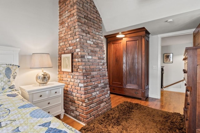 bedroom with lofted ceiling and light wood-type flooring