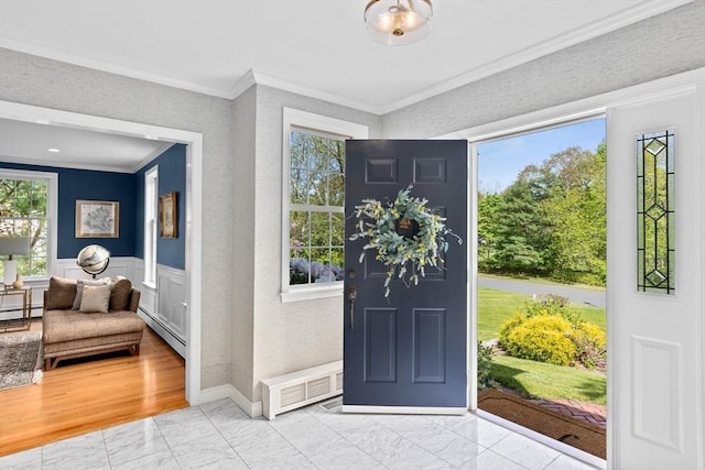 foyer entrance featuring a baseboard radiator and ornamental molding