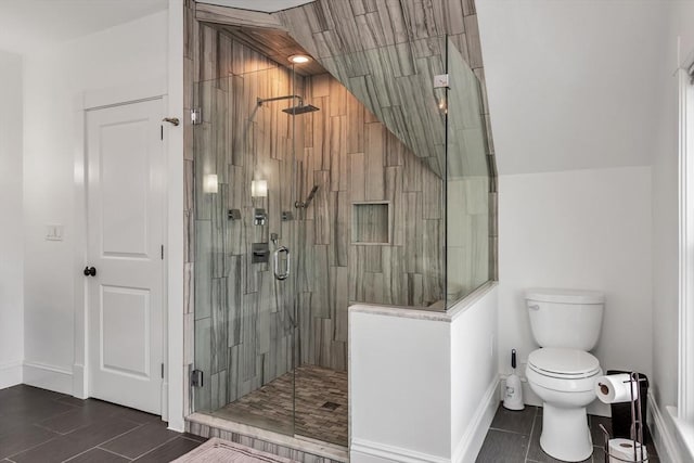 bathroom with toilet, a shower stall, baseboards, and tile patterned floors