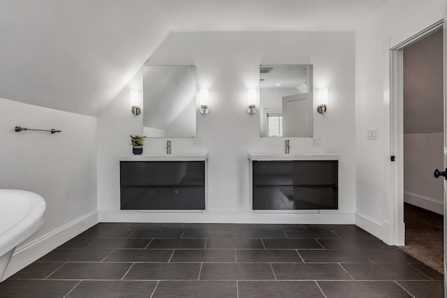 full bathroom featuring lofted ceiling, vanity, and baseboards