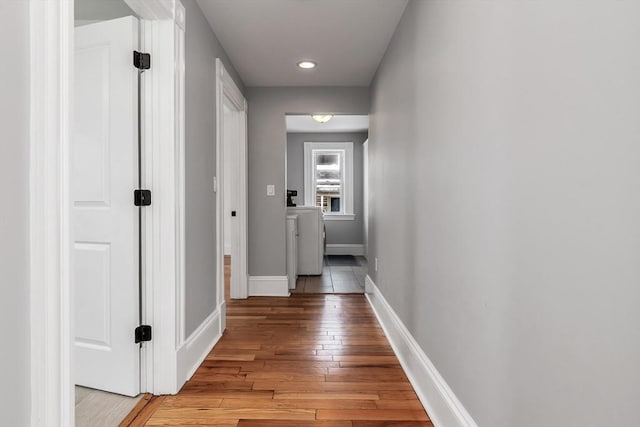 hallway featuring washer / dryer, recessed lighting, light wood-style flooring, and baseboards