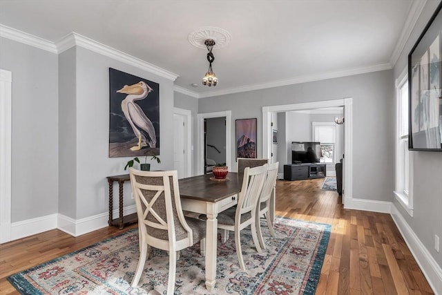 dining space featuring baseboards, a notable chandelier, and hardwood / wood-style floors