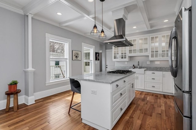 kitchen with stainless steel appliances, coffered ceiling, island exhaust hood, and hardwood / wood-style floors