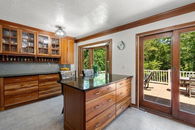 198 Edge Hill Rd, Sharon, MA 02067 - kitchen featuring brown cabinetry, healthy amount of natural light, tasteful backsplash, crown molding, and glass insert cabinets