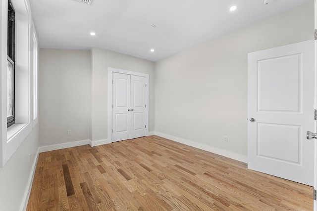 unfurnished bedroom featuring light wood-type flooring and a closet