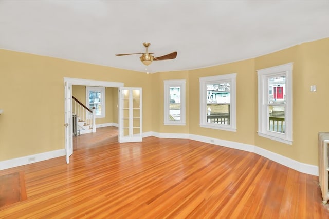 empty room with a healthy amount of sunlight, light wood finished floors, and baseboards