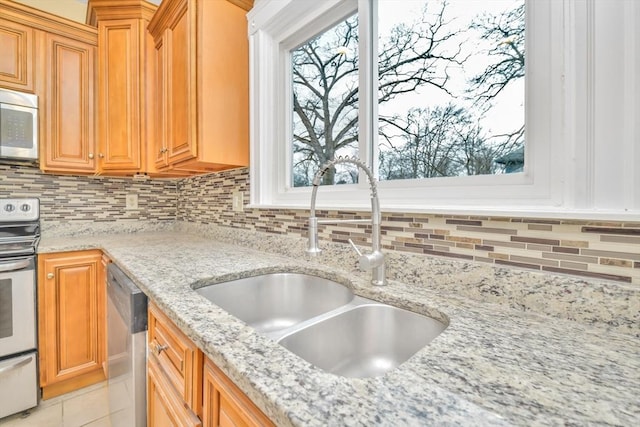 kitchen featuring a wealth of natural light, backsplash, stainless steel appliances, and a sink