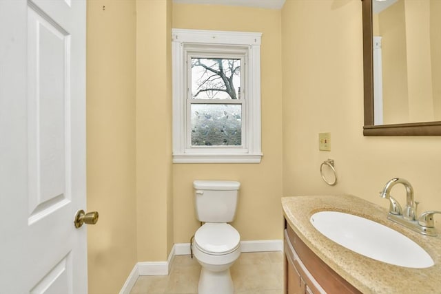 bathroom with toilet, vanity, baseboards, and tile patterned floors