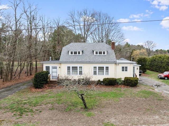 view of front of home featuring a chimney and a shingled roof