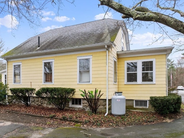 view of side of home featuring a shingled roof