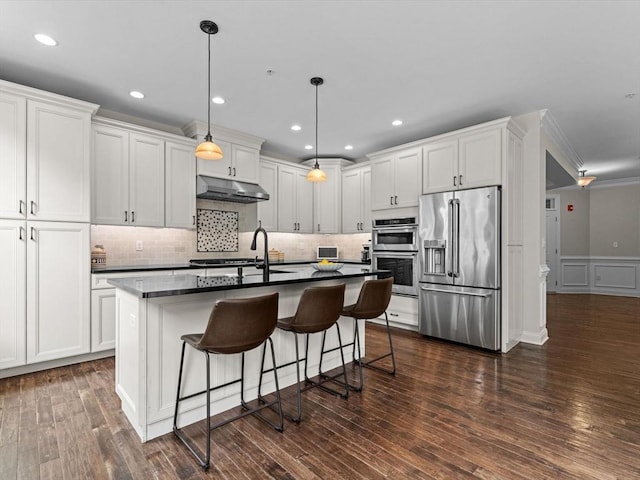 79 Townsend Blvd Unit 79, Westborough, MA 01581 - kitchen with stainless steel appliances, dark countertops, under cabinet range hood, white cabinetry, and ornamental molding