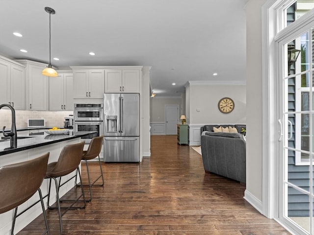 79 Townsend Blvd Unit 79, Westborough, MA 01581 - kitchen with stainless steel appliances, crown molding, dark wood finished floors, backsplash, and hanging light fixtures