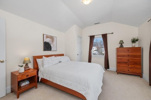 carpeted bedroom with lofted ceiling