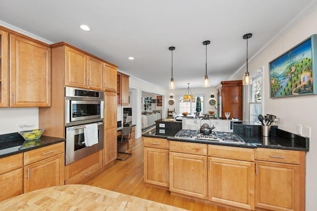 kitchen with hanging light fixtures, stainless steel appliances, ornamental molding, kitchen peninsula, and light wood-type flooring