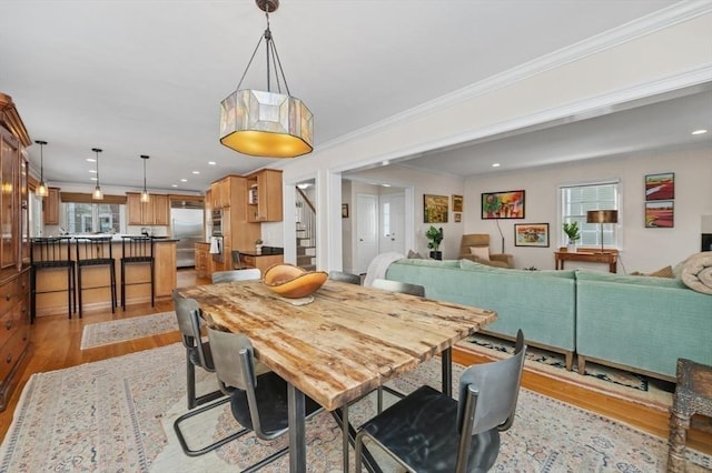 dining area featuring crown molding and light wood-type flooring