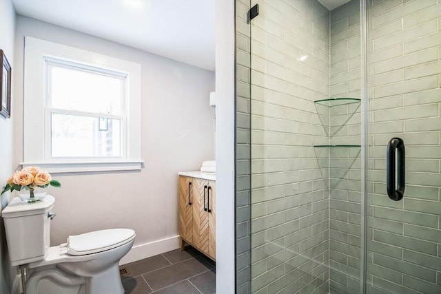 bathroom featuring a shower with door, tile patterned floors, toilet, and vanity