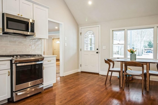 kitchen featuring white cabinetry, lofted ceiling, stainless steel appliances, and tasteful backsplash