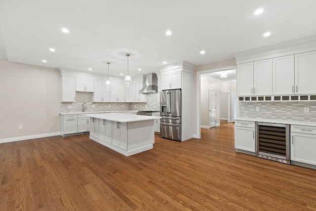 11 Olde Stable Ln, Easton, MA 02356 - kitchen featuring stainless steel fridge with ice dispenser, beverage cooler, wall chimney exhaust hood, backsplash, and light countertops