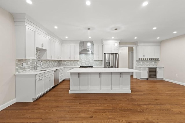 11 Olde Stable Ln, Easton, MA 02356 - kitchen featuring appliances with stainless steel finishes, wall chimney exhaust hood, beverage cooler, a kitchen island, and light countertops