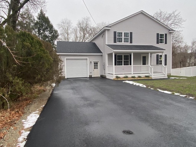 view of property featuring a front yard, a porch, and a garage