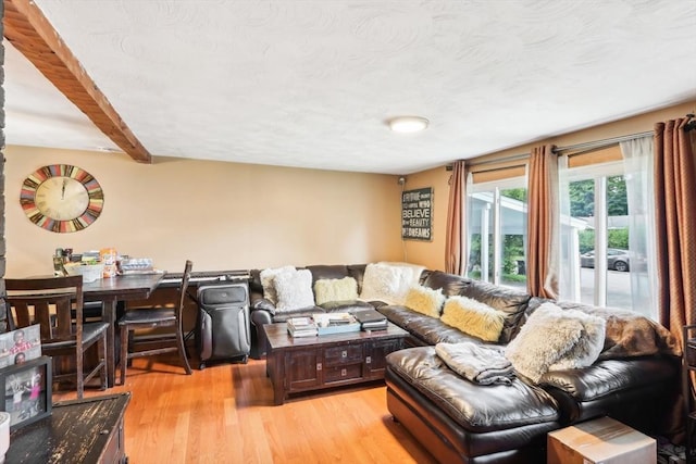 living room with beam ceiling and light wood-type flooring