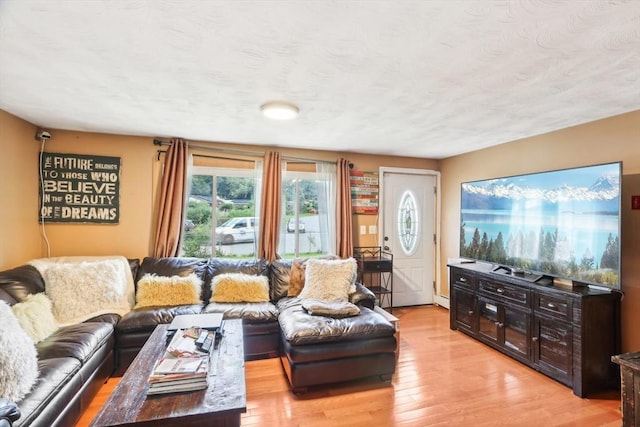 living room featuring a textured ceiling, a baseboard radiator, and light hardwood / wood-style flooring