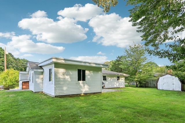 back of house featuring a yard and a storage unit