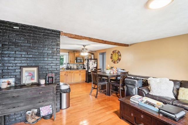 living room featuring beam ceiling and light hardwood / wood-style flooring