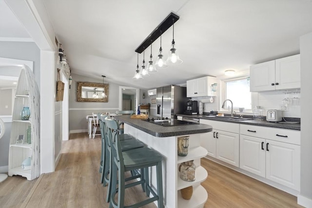 kitchen featuring a kitchen island, stainless steel refrigerator with ice dispenser, dark countertops, open shelves, and a breakfast bar