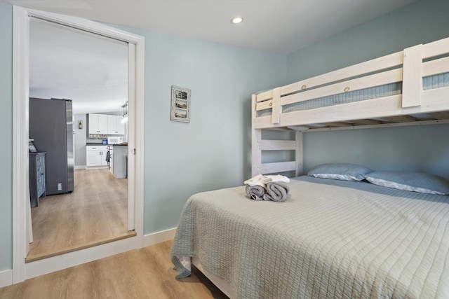 bedroom featuring freestanding refrigerator, recessed lighting, baseboards, and light wood-type flooring