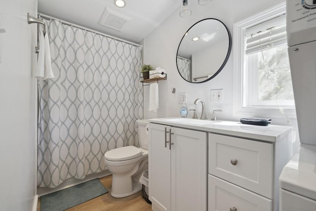 full bath featuring vanity, toilet, a shower with shower curtain, wood finished floors, and visible vents