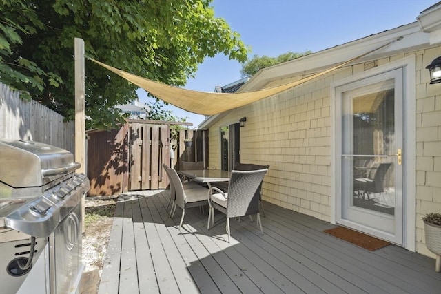 wooden deck with fence, outdoor dining space, and area for grilling