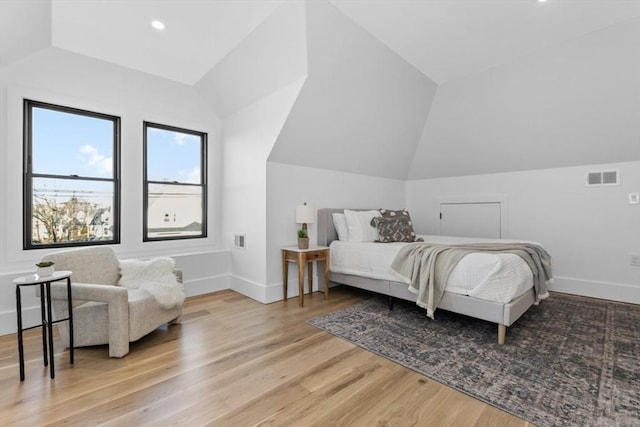 bedroom featuring light wood-type flooring and lofted ceiling