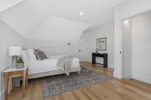 bedroom with lofted ceiling and light hardwood / wood-style flooring