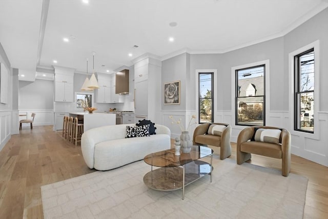 living room featuring light hardwood / wood-style floors and crown molding