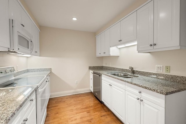 kitchen with white cabinetry, light hardwood / wood-style floors, white appliances, light stone countertops, and sink