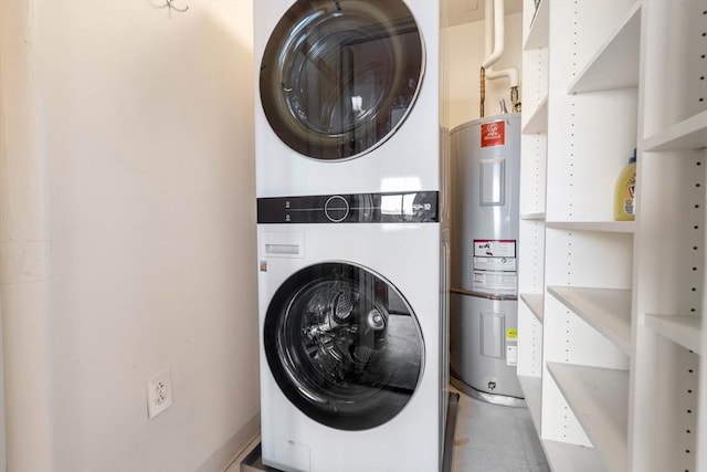 clothes washing area featuring electric water heater and stacked washing maching and dryer